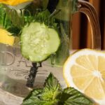 Fresh slices of lemon and cucumber in a mason jar with mint leaves, perfect for a summer refreshment.
